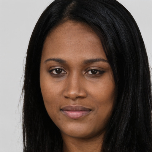 Joyful black young-adult female with long  black hair and brown eyes