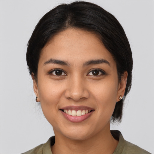 Joyful latino young-adult female with medium  brown hair and brown eyes