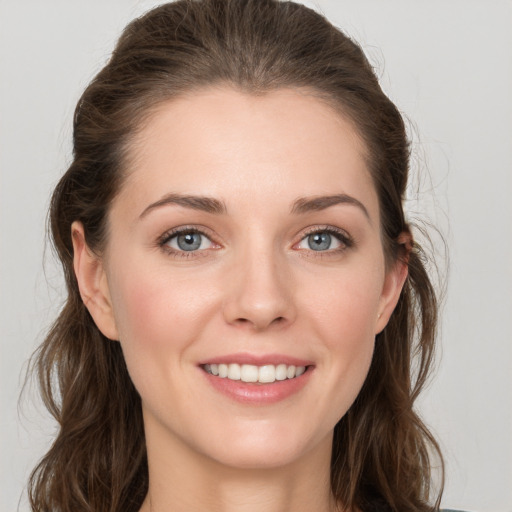 Joyful white young-adult female with long  brown hair and grey eyes