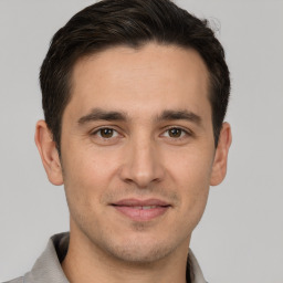 Joyful white young-adult male with short  brown hair and brown eyes