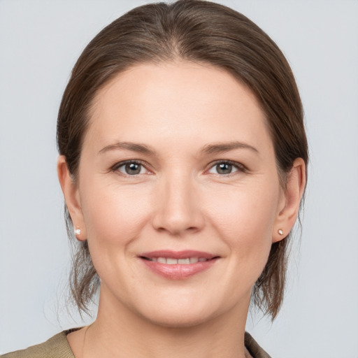 Joyful white young-adult female with medium  brown hair and grey eyes