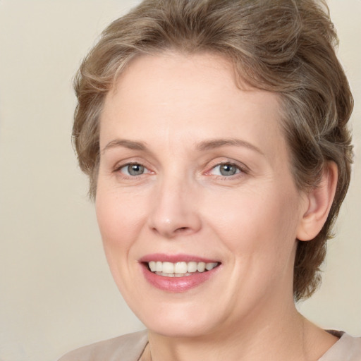 Joyful white adult female with medium  brown hair and grey eyes