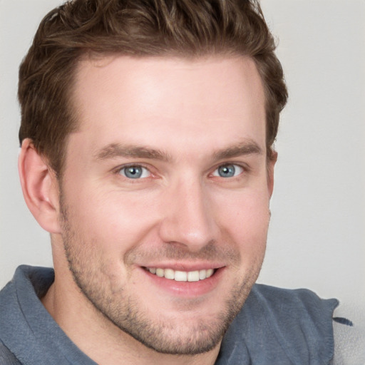 Joyful white young-adult male with short  brown hair and grey eyes