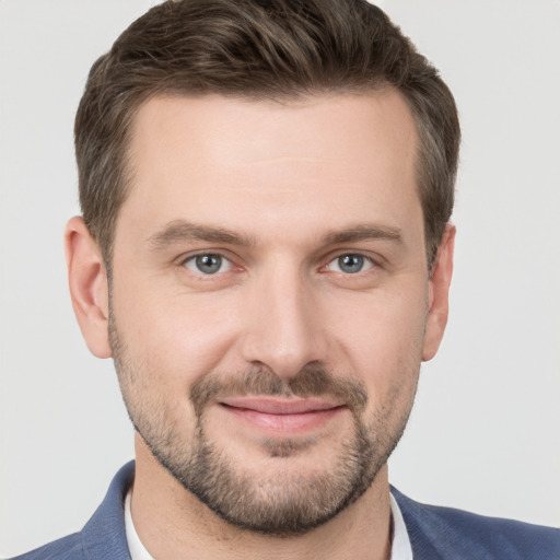 Joyful white young-adult male with short  brown hair and grey eyes