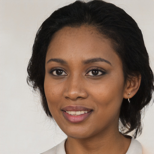 Joyful black young-adult female with medium  black hair and brown eyes