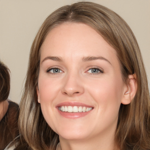 Joyful white young-adult female with medium  brown hair and grey eyes