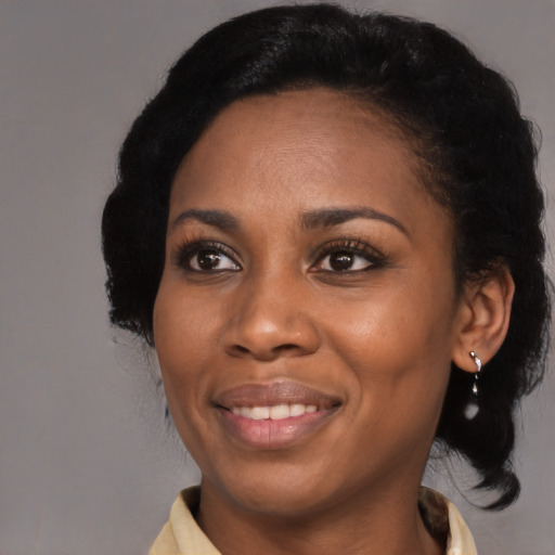 Joyful black adult female with medium  black hair and brown eyes