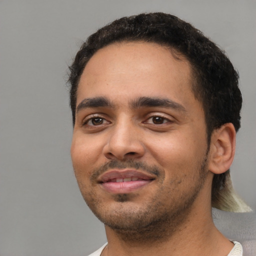 Joyful latino young-adult male with short  black hair and brown eyes
