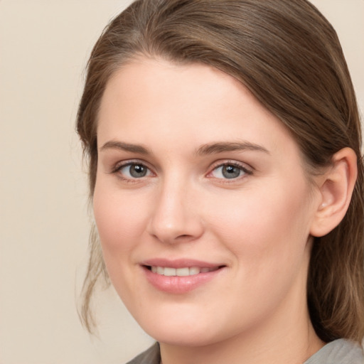 Joyful white young-adult female with medium  brown hair and grey eyes