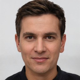 Joyful white young-adult male with short  brown hair and grey eyes