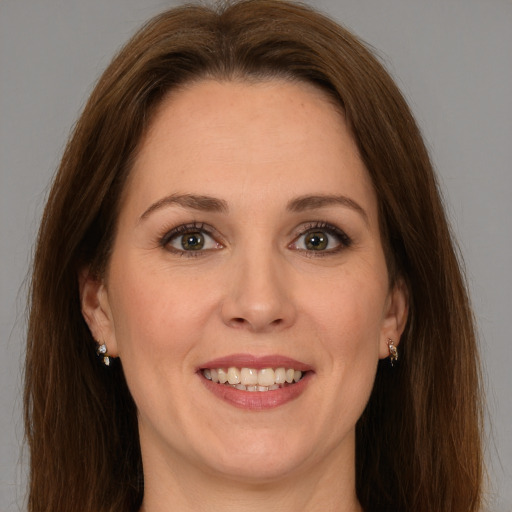 Joyful white young-adult female with long  brown hair and green eyes