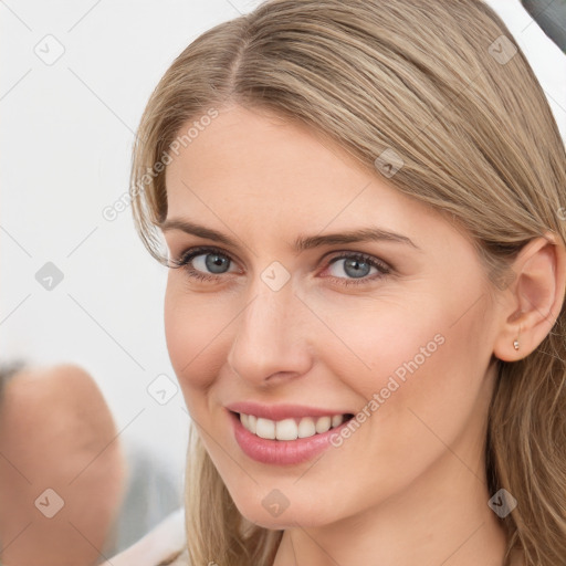 Joyful white young-adult female with long  brown hair and blue eyes