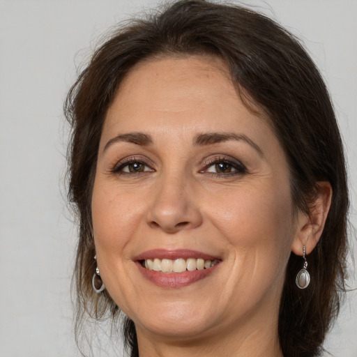 Joyful white adult female with long  brown hair and brown eyes