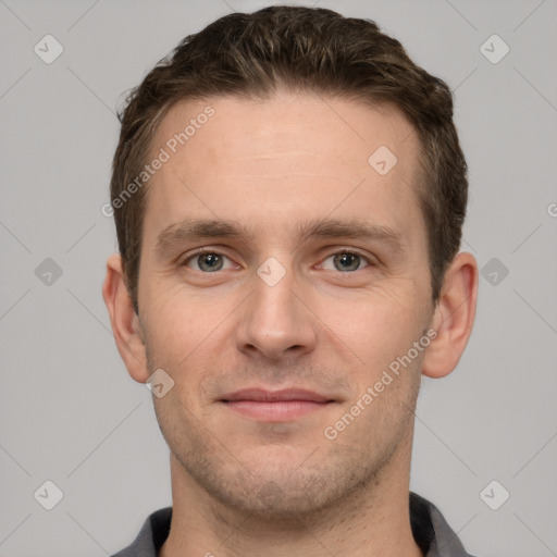 Joyful white young-adult male with short  brown hair and grey eyes