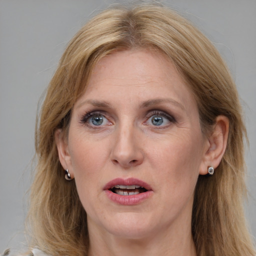 Joyful white adult female with medium  brown hair and blue eyes