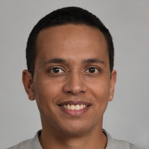 Joyful latino young-adult male with short  brown hair and brown eyes