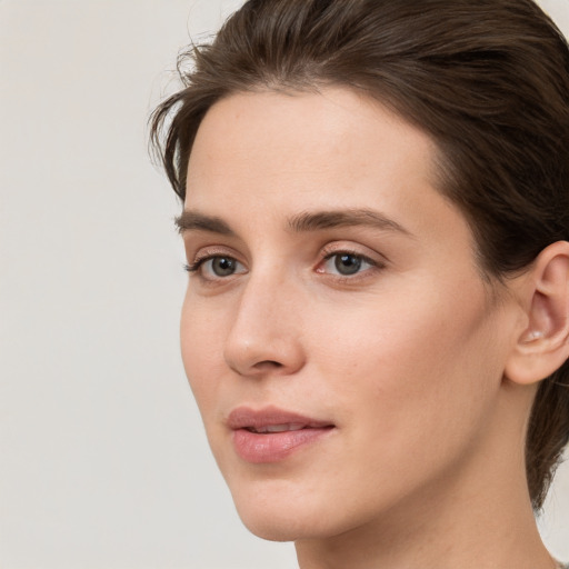 Joyful white young-adult female with medium  brown hair and grey eyes