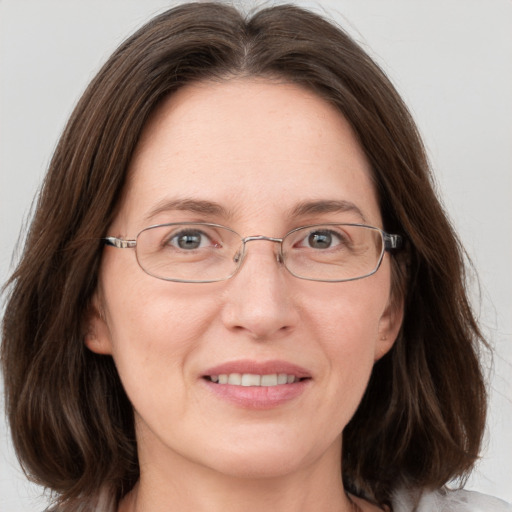 Joyful white adult female with medium  brown hair and grey eyes