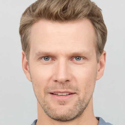 Joyful white young-adult male with short  brown hair and grey eyes