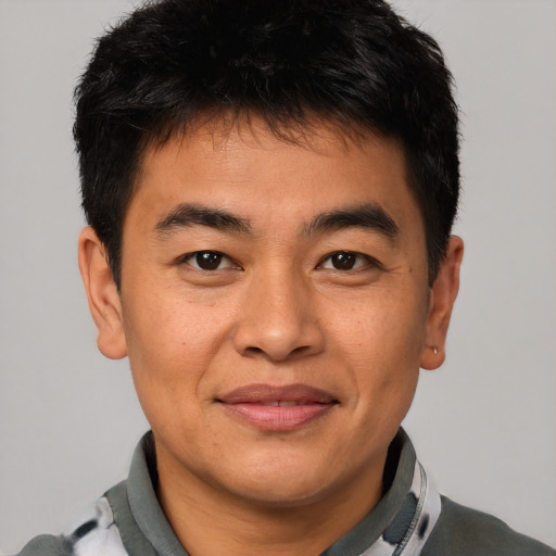 Joyful asian young-adult male with short  brown hair and brown eyes