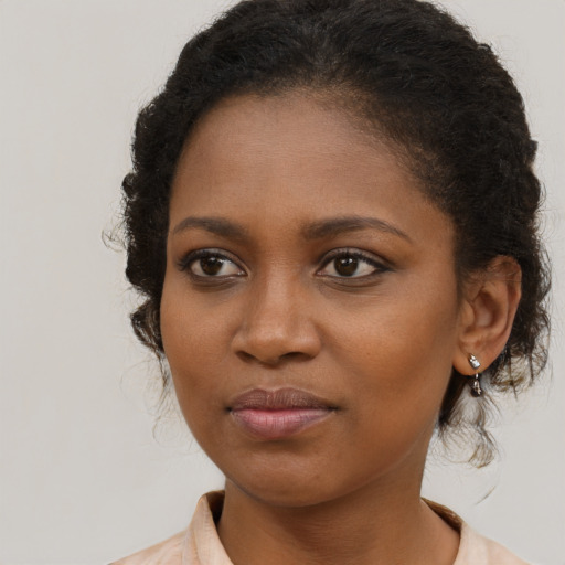 Joyful black young-adult female with long  brown hair and brown eyes