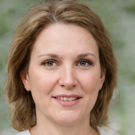 Joyful white adult female with medium  brown hair and green eyes