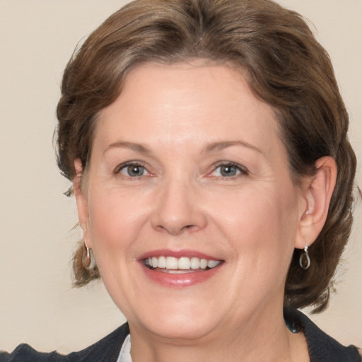 Joyful white adult female with medium  brown hair and grey eyes