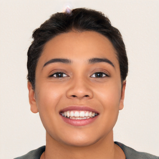 Joyful latino young-adult female with short  black hair and brown eyes