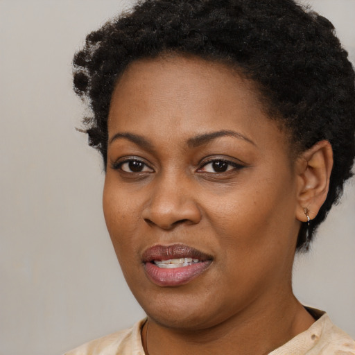 Joyful black young-adult female with short  black hair and brown eyes