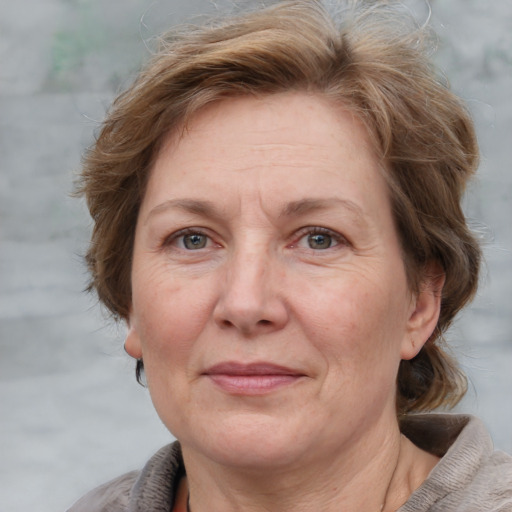 Joyful white adult female with medium  brown hair and grey eyes