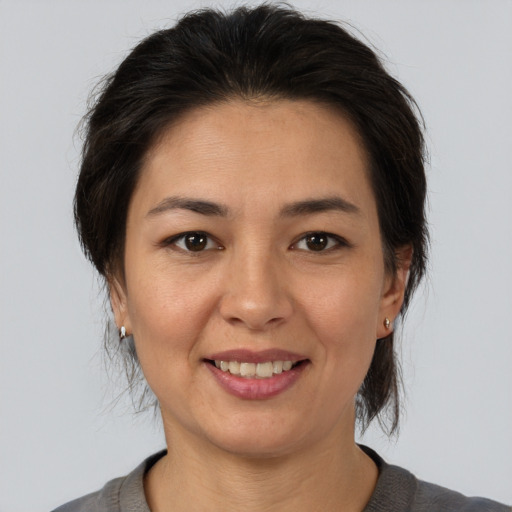 Joyful asian adult female with medium  brown hair and brown eyes