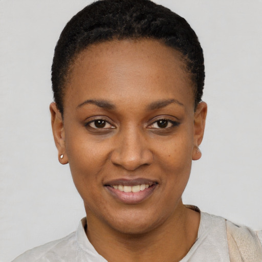 Joyful black young-adult female with short  black hair and brown eyes