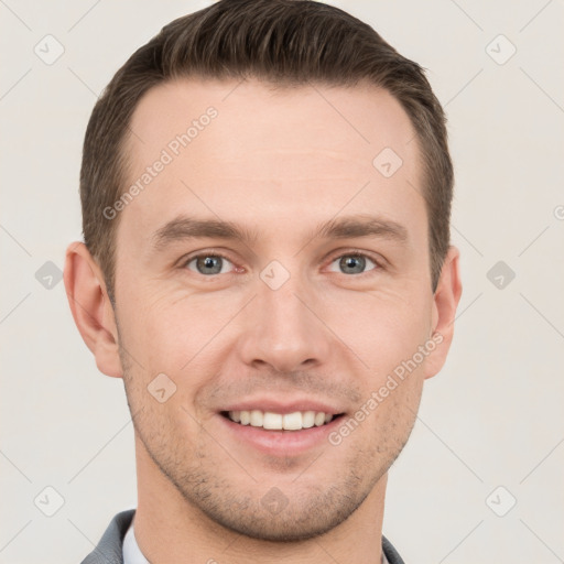 Joyful white young-adult male with short  brown hair and grey eyes