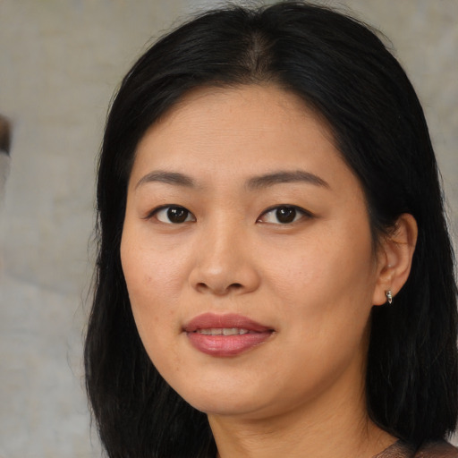 Joyful asian young-adult female with long  brown hair and brown eyes