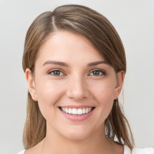 Joyful white young-adult female with medium  brown hair and grey eyes