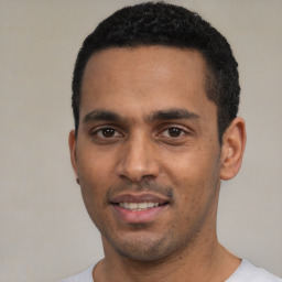 Joyful white young-adult male with short  black hair and brown eyes