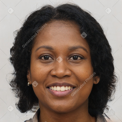 Joyful black young-adult female with long  brown hair and brown eyes