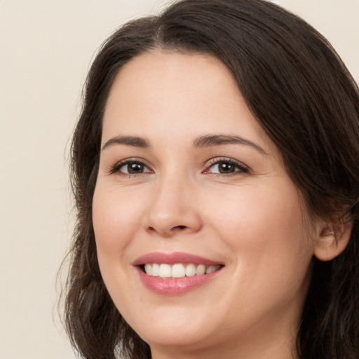 Joyful white young-adult female with long  brown hair and brown eyes