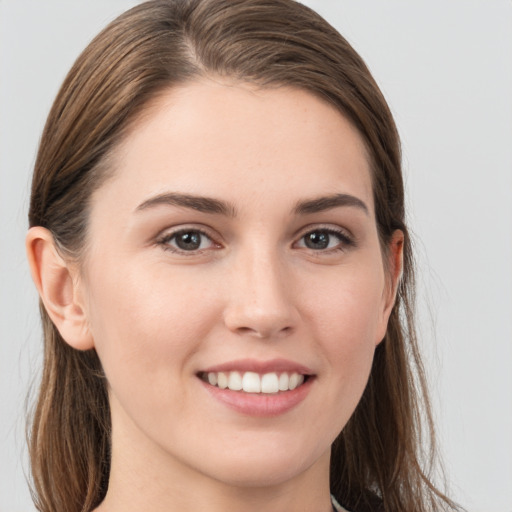 Joyful white young-adult female with long  brown hair and grey eyes