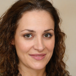 Joyful white adult female with long  brown hair and brown eyes