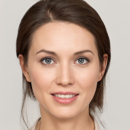 Joyful white young-adult female with medium  brown hair and grey eyes