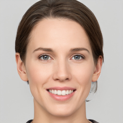 Joyful white young-adult female with medium  brown hair and grey eyes