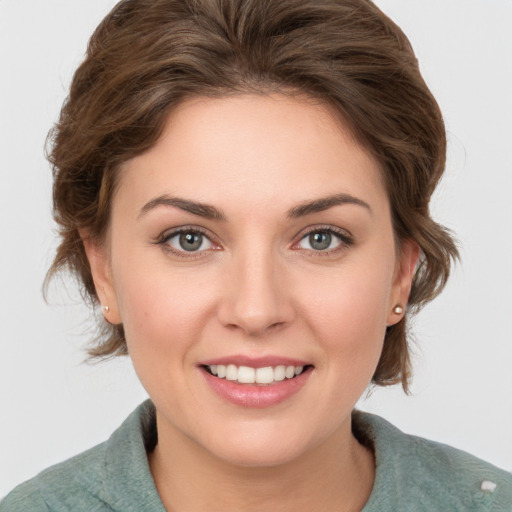 Joyful white young-adult female with medium  brown hair and green eyes