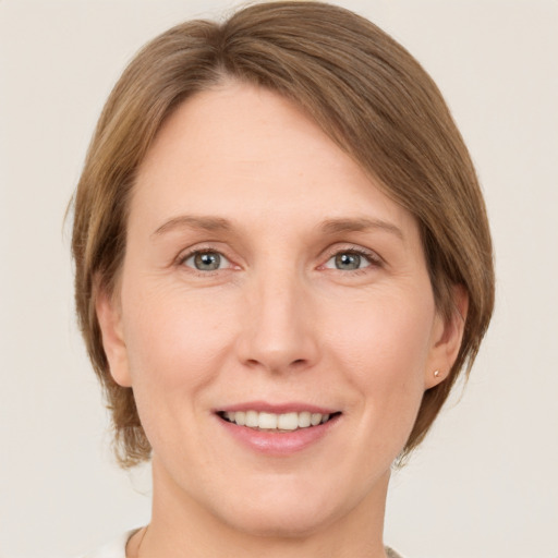 Joyful white adult female with medium  brown hair and grey eyes