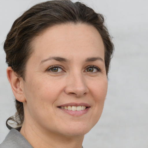 Joyful white adult female with short  brown hair and grey eyes