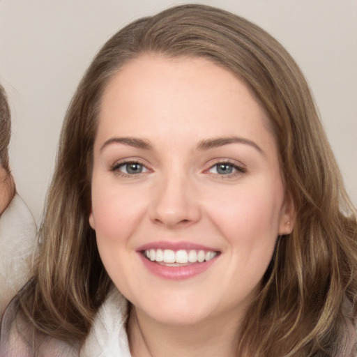 Joyful white young-adult female with long  brown hair and brown eyes