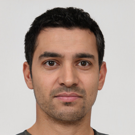 Joyful white young-adult male with short  black hair and brown eyes