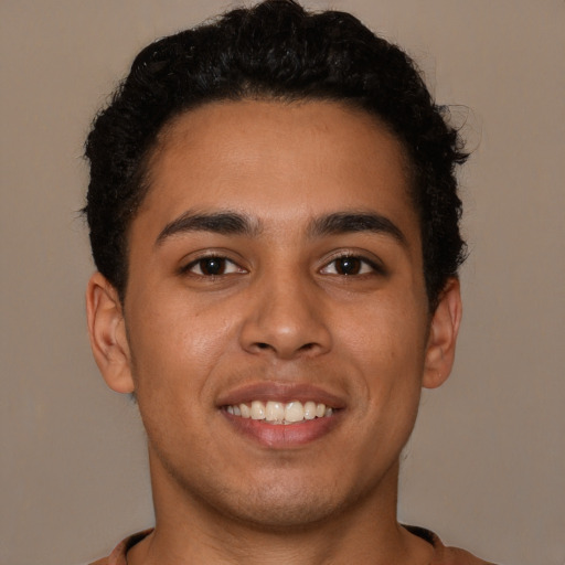 Joyful latino young-adult male with short  brown hair and brown eyes