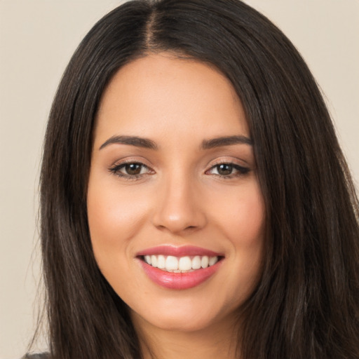 Joyful latino young-adult female with long  brown hair and brown eyes