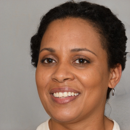 Joyful black adult female with short  brown hair and brown eyes